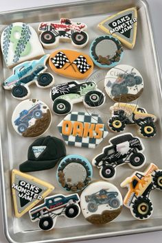 decorated cookies in the shape of cars and trucks are on a tray with dirt tires