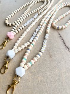 a white beaded necklace with two gold toned metal clasps and an antique key