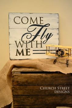 a wooden sign that says come fly with me on top of an old trunk and box