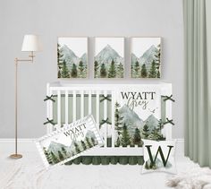 a baby's room with mountains and trees on the wall, bedding and decor