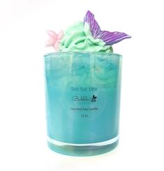 a candle that has some kind of sea salt mist in it with a butterfly on top