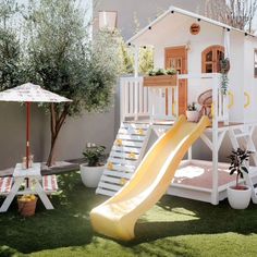 a play house with a slide in the grass