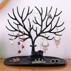 a tree with earrings on it sitting on top of a table