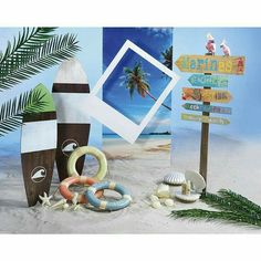 an assortment of beach themed items on the sand with palm trees and signs in the background