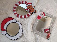 three christmas themed mirrors sitting on top of a white blanket next to a teddy bear