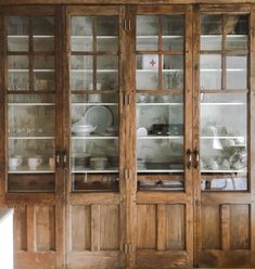 an old wooden china cabinet with glass doors