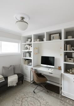 a home office with built - in shelving units and a computer on the desk