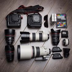 many different cameras and accessories laid out on the floor