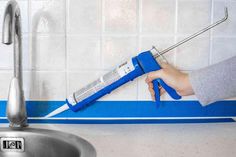 a person using a wrench to fix a sink faucet