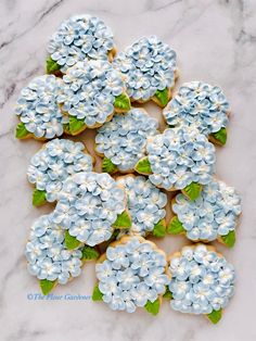 cookies decorated with blue and white flowers on a marble countertop, ready to be eaten