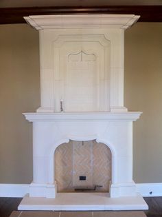 an empty fireplace in a living room with tile flooring and white painted mantles