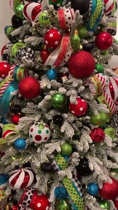 a christmas tree decorated with colorful ornaments and ribboned balls is shown in this image