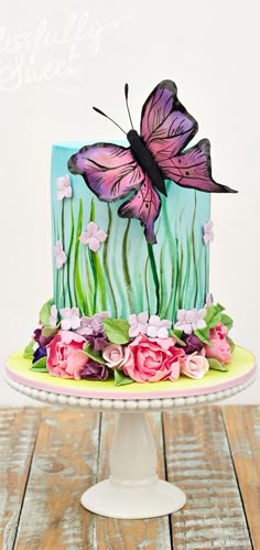 a cake decorated with flowers and a butterfly on top