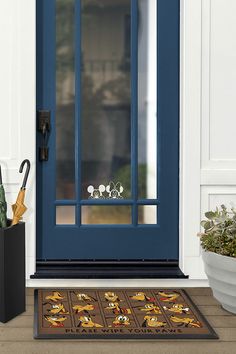 a blue front door with an umbrella and other items on the mat next to it