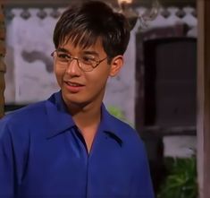 a young man wearing glasses and a blue shirt