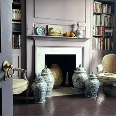 a living room filled with furniture and a fire place in front of a book shelf