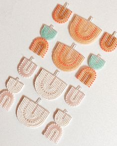 six pairs of beaded earrings on a white surface with an orange and blue design