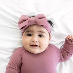 Child laying on a bed wearing a Dusty Plum luxe bow headband Newborn Bows Headband, Newborn Headband Bow, Floral Swaddle And Headband, Big Bow Headband Baby, Purple Infant Clothes, Lemonade Stand, Newborn Headbands, Child Safety, Fall Favorites