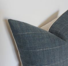 a blue and white striped pillow sitting on top of a bed