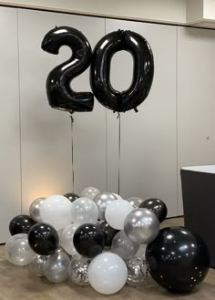 black and white balloons in the shape of numbers are on display at an office party