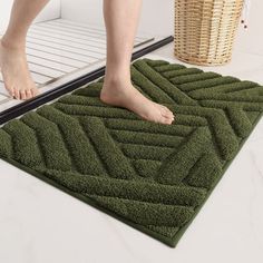 a person is standing on a mat in the bathroom