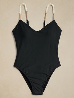 One-piece swimsuit featuring elastic cord and resin details on the straps.  The adjustable parallel straps and back neckline ensure a customized fit, and with removable padded cups, it combines comfort and style seamlessly.  This one piece doubles as a bodysuit and can be styled casually with your favorite pair of jeans.  SWIMWEAR: Beloved for luxurious touches—like touches of leather and 24K gold-plated hardware—Paula Hermanny launched Swimwear in the United States in the early 2000s, designing hand-crafted pieces, inspired by Brazilian beach culture, for women who appreciate beauty, quality and attention to detail.  Elastic cord details Resin accents 24k gold-plated details Adjustable shoulder straps Fully lined Made in Brazil Brazilian-style high-cut legs, cheeky fit at back.  S: Bust 3 Bathing Suits One Piece, Swimsuit Trends, Safari Style, Fashionista Clothes, Summer Bikinis, Swimsuits For All, Best Black, Black Swimsuit, Swimwear Fashion