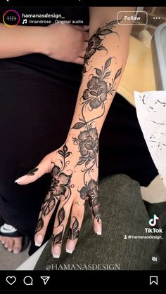 a woman's hand with black flowers on it and the words henna design