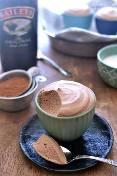 two bowls filled with chocolate pudding on top of a wooden table