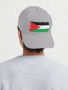 a man wearing a hat with the flag of jordan painted on it's side