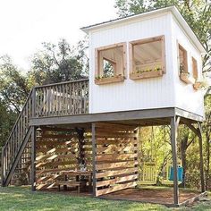 a small white house sitting on top of a lush green field