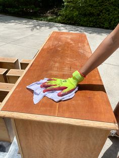 a person with yellow gloves on top of a wooden table