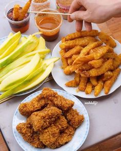 two plates with fried food on them and some dipping sauces next to each other