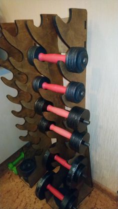 a wine rack made out of wood with pink and black dumbbells on it