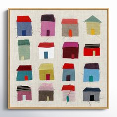 an art print with houses painted on it in various colors and sizes, hanging on a wall