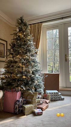 a christmas tree with presents under it in a living room