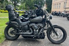 several motorcycles are parked on the side of the road in front of some buildings and trees