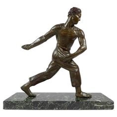 a bronze statue of a man holding a tennis racquet on a marble base