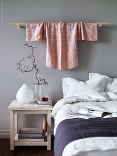 a bed room with a neatly made bed and two vases on the end tables