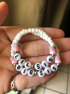 a person holding a bracelet with beads and letters that spell the word bliss on it