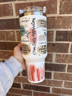 a person holding up a cup with some writing on it