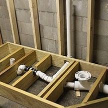 an unfinished bathroom with pipes and toilet in it