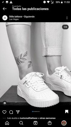 a person with tattoos on their legs standing next to a pair of white shoes and leggings