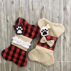 two christmas stockings hanging on the wall with dog paw and plaid stocking attached to them