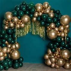 an arch made out of balloons and streamers on the floor in front of a blue wall