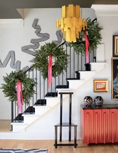 a staircase decorated with christmas decorations and potted plants