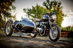 a black motorcycle parked on top of a dirt road