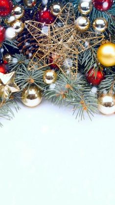 christmas decorations and pine branches with snow on the ground in front of white space for text