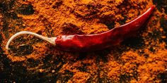 a red chili pepper on a pile of ground spices