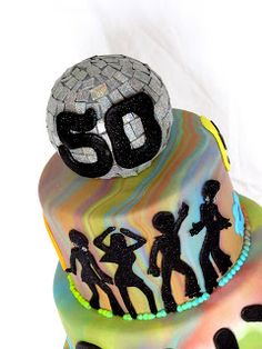 a birthday cake decorated with the number 50 and silhouettes of people dancing on it