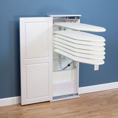 a white surfboard mounted to the side of a cabinet in a room with blue walls